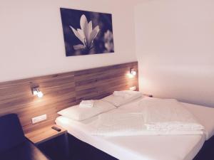 弗拉绍唐恩维尔公寓的卧室配有白色的床和木制床头板