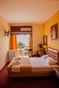 雅典加利尼宫酒店的一间设有大床和窗户的酒店客房