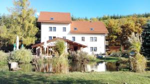 别洛赫拉德矿泉村杨维斯基穆林旅馆的一座白色的大房子,前面有一个池塘