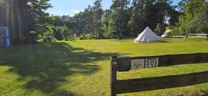 CarpinTipi Jurte Camping in der Mecklenburgischen Seenplatte inklusive Strom - Dixi-WC!!的地势为一个有帐篷的地基和一个栅栏