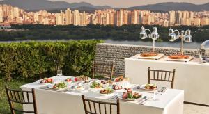 首尔华克山庄首尔大酒店的一张桌子和白色的桌椅,享有城市美景