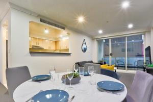 悉尼Stylish 2 Bedroom Apartment Haymarket的一间配备有白色桌椅的用餐室
