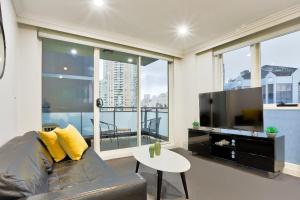 悉尼Stylish 2 Bedroom Apartment Haymarket的带沙发和大窗户的客厅