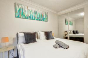 悉尼Stylish 2 Bedroom Apartment Haymarket的卧室配有一张大白床和大镜子