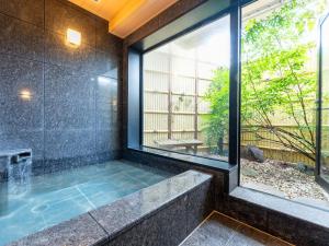 东京Tabist TOKYO CITY VIEW HOTEL的一间带大窗户和浴缸的浴室