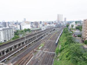 东京Tabist TOKYO CITY VIEW HOTEL的享有带火车轨道的城市美景