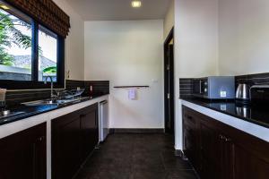 拉威海滩Phuket Pool Residence - Adults only的厨房配有水槽和微波炉