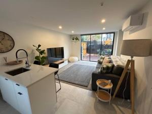 基督城Luxury 2 Bedroom Hideout Near CBD,Merivale Mall的厨房以及带沙发和电视的客厅。