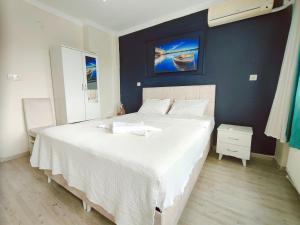 伊斯坦布尔Alpacino Apart Hotel的一间卧室配有一张白色大床和蓝色的墙壁