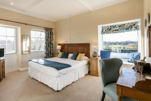 凯尔索爱德纳姆之家酒店的一间卧室配有一张床、一张书桌和一个窗户。