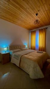 KomanLugina e Komanit的一间卧室设有一张大床和木制天花板