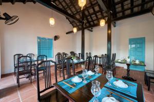 会安Hoi An Legend Charm Boutique Hotel的一间在房间内配有桌椅的餐厅