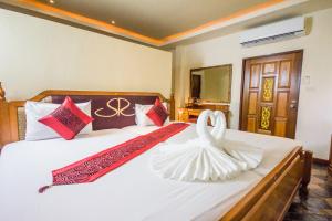 利巴诺伊暹罗原住精品度假酒店的酒店客房,配有一张带天鹅的床