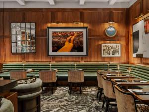 费城Sofitel Philadelphia at Rittenhouse Square的餐厅拥有木墙和桌子,墙上挂着一幅画