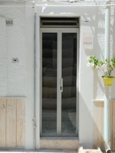 滨海波利尼亚诺Dimora Dioniso的白色房子的玻璃门,有楼梯