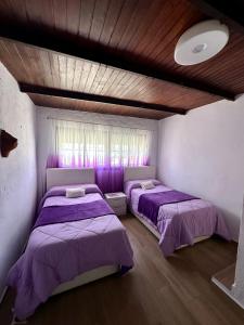 博罗尼亚House Beach的紫色床单的客房内的两张床