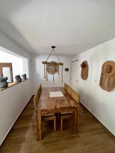 博罗尼亚House Beach的一间带木桌和椅子的用餐室