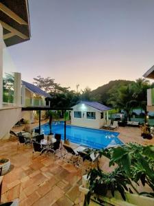 鲍巴鲍巴海滩酒店的一个带椅子的游泳池以及一座房子