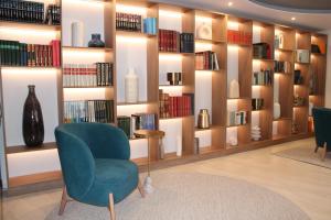 锡尼什斯纳拉马公寓酒店的图书馆,藏有蓝色椅子和书籍