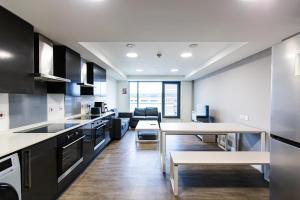 谢菲尔德New Era Living - Ensuite Rooms with Shared Kitchen的厨房配有黑白电器和桌子