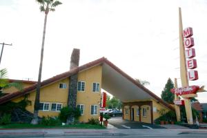 奥兰治天空棕榈汽车旅馆 - 橙色的黄色的建筑,前面有标志