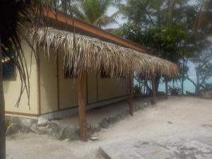 PareaCamping Hiva Plage的海滩上带草屋顶的建筑