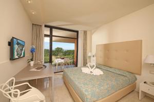 西尔米奥奈假日公寓酒店的配有一张床、一张书桌和一扇窗户的酒店客房