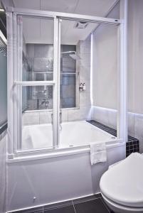 台北V-one - 宁夏2号旅店的带浴缸、卫生间和淋浴的浴室。