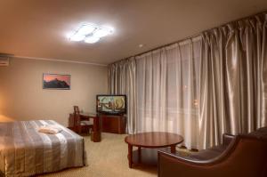 阿拉木图远航酒店的酒店客房设有床、桌子和窗户。
