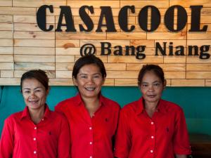 蔻立卡萨库尔酒店的三个穿着红衬衫的女人站在一个标志牌前