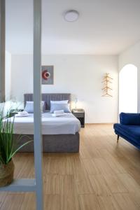 SurčinAirport Stay Apartments的一间卧室配有一张床和一张蓝色的沙发
