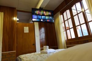奥克萨潘帕Hospedaje Vista Verde的卧室配有一张床铺,墙上配有电视