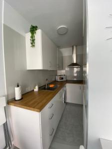 圣克鲁斯-德特内里费Apartamento moderno y familiar Live Santa Cruz Centro的厨房配有白色橱柜和水槽