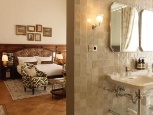 布鲁塞尔Hotel Fleur de Ville的一间带水槽的浴室和一张带镜子的床