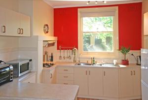 汉道夫奥茨度假屋的厨房设有红色的墙壁、水槽和窗户