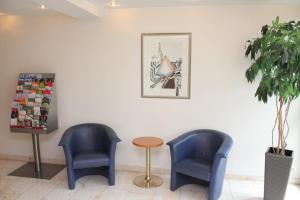 莱因费尔登-埃希特尔丁根太阳酒店的候诊室配有2把蓝色椅子和1张桌子