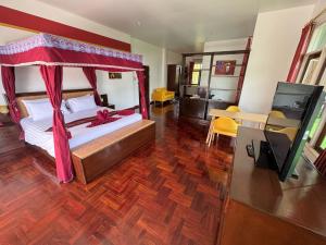 Sathing Phra敖泰度假酒店的一间卧室配有一张红色天蓬床