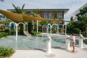 蔻立Pullman Khao Lak Resort的站在带水上乐园的游泳池中的儿童