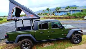 卡胡卢伊CampCar Maui Jeeps SUVs Hybrid Camper van Rentals with equipment and Travel Advice的一辆绿色吉普车,上面有帐篷