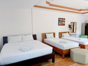 北碧ชอว์ งาทอง รีสอร์ต Chor Ngar Thong Erawan的一间卧室配有两张带白色床单的床