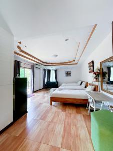北碧ชอว์ งาทอง รีสอร์ต Chor Ngar Thong Erawan的一间铺有木地板并配有床的大卧室