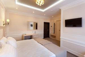 克拉斯诺达尔Chocolatier Hotel的卧室配有白色的床和电视。