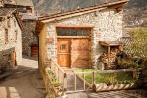 恩坎普R de Rural - Casa Rural de les Arnes的石头房子的一侧设有木门