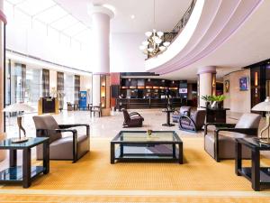 布加勒斯特普尔曼布加勒斯特世界贸易中心酒店的大厅,在大楼里设有沙发和桌子