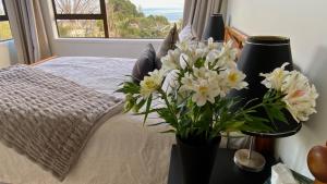 泰晤士Fantail Hill的一间卧室,配有一张带花瓶的床