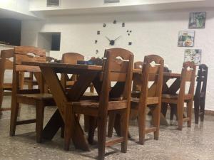 埃里温Hotel Tigran Mets的木餐桌和椅子,墙上挂着时钟