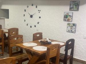 埃里温Hotel Tigran Mets的一张带椅子的木桌和墙上的时钟