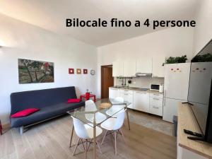 San Giorgio di PianoLa Casa di Leo Apartments的客厅配有蓝色的沙发和玻璃桌