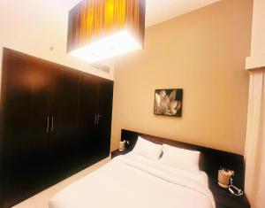 迪拜AlRaef Luxury Apartments的一间卧室配有一张带黑色床头板的床