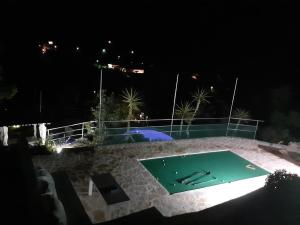 科尔丘拉Relax tiny villas 40 meters of the beach的游泳池,晚上带绿色泳池